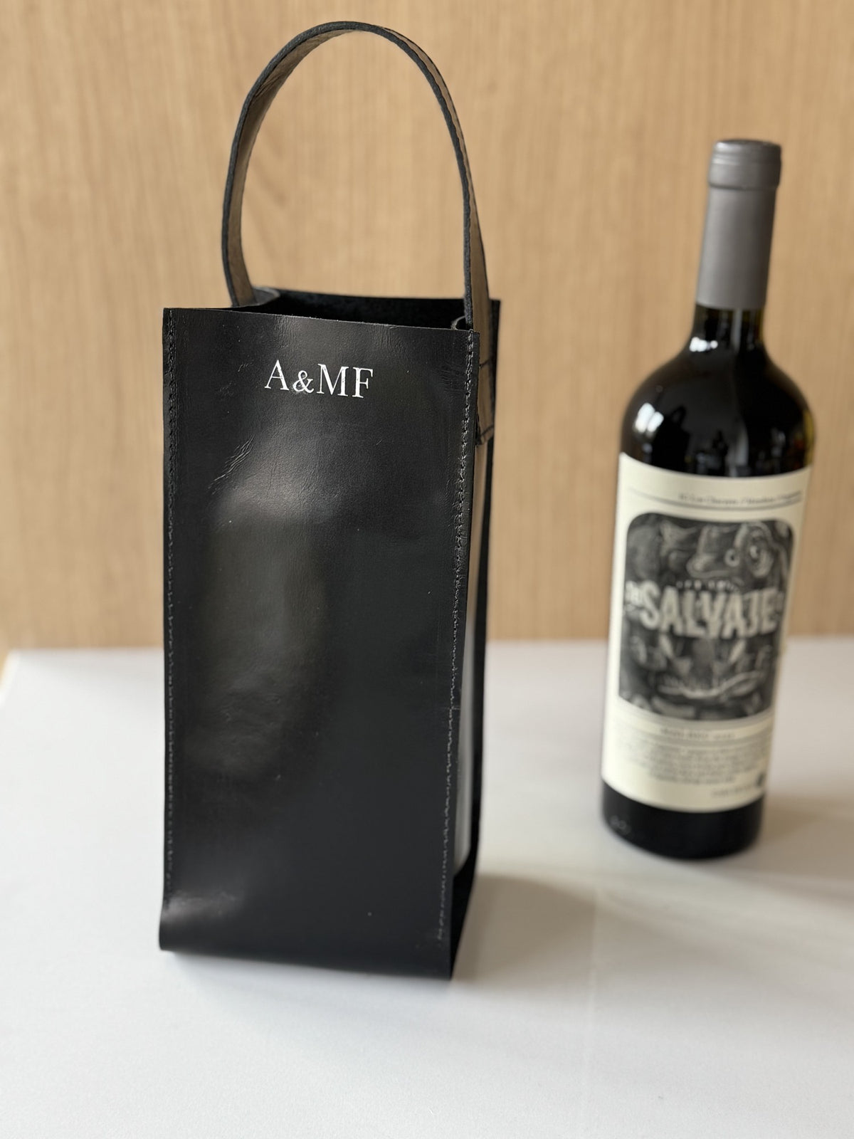 Wine bag de couro personalizada ao lado da garrafa